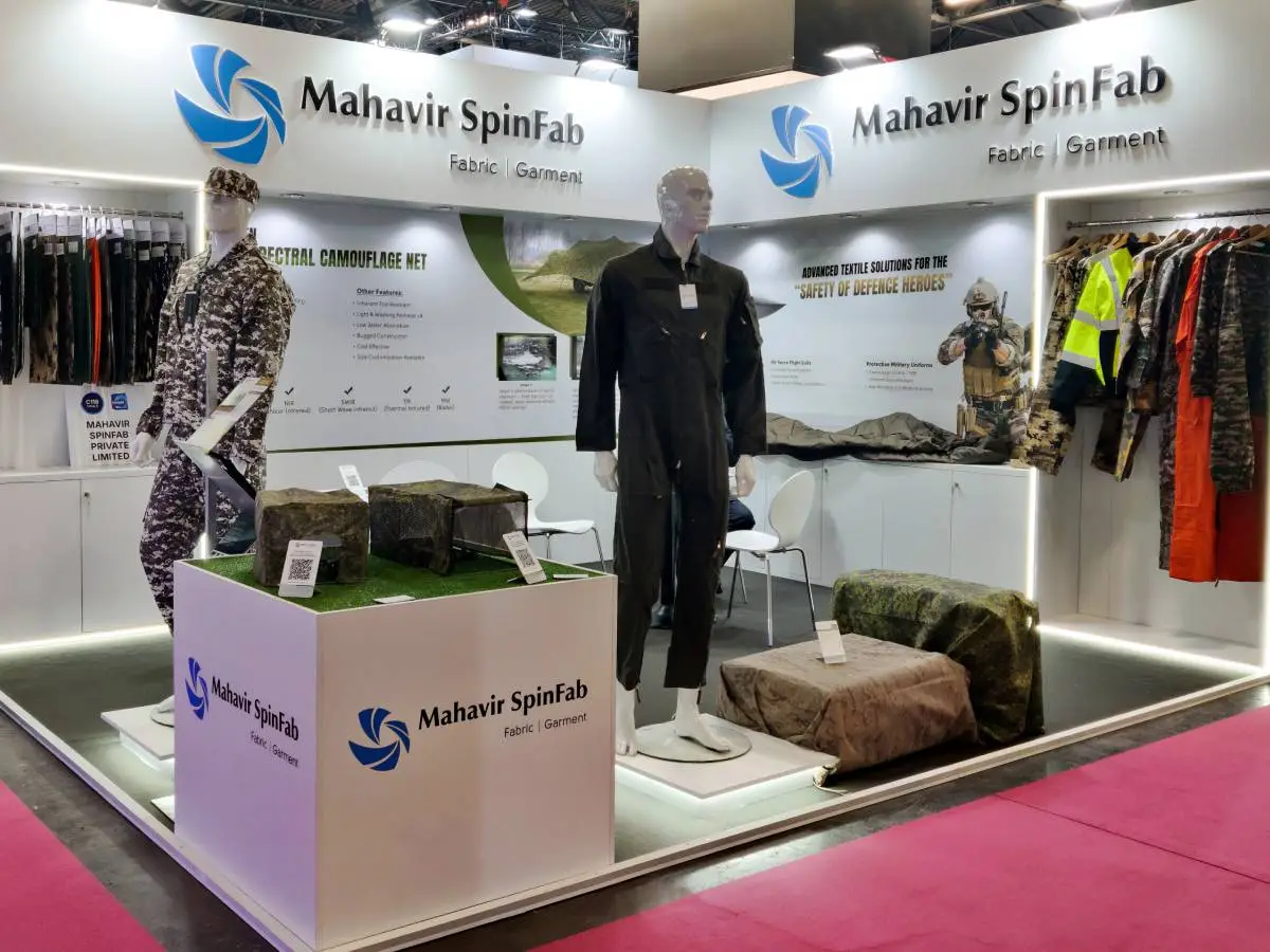 Full view of Mahavir Spinfab exhibition stand in Paris featuring military flight suits, combat gear, and MSCN technology.